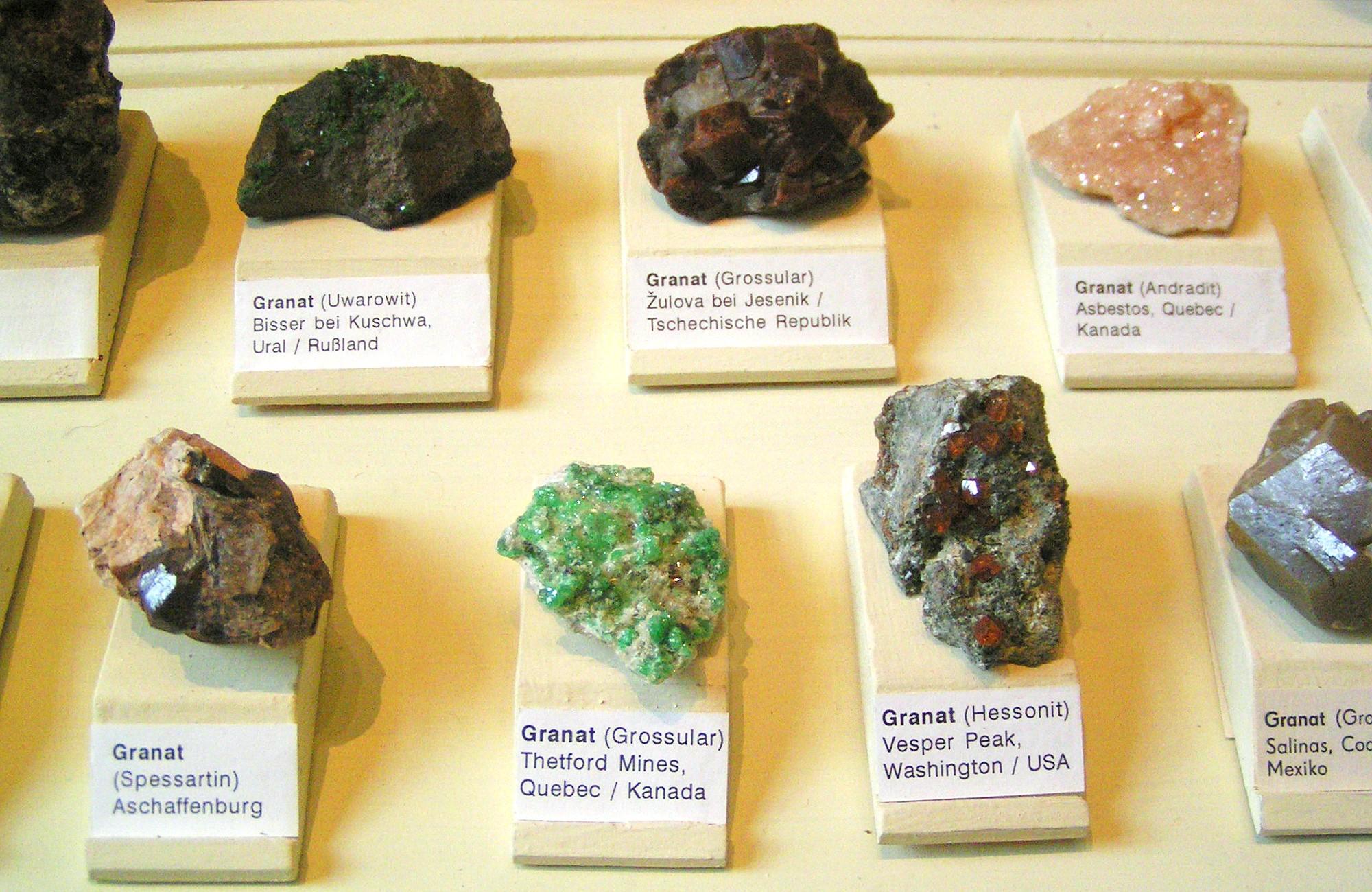 Auslage Mineralien im Naturkundemuseum Berlin - Steinproben Granat mit Herkunftsbezeichnung
